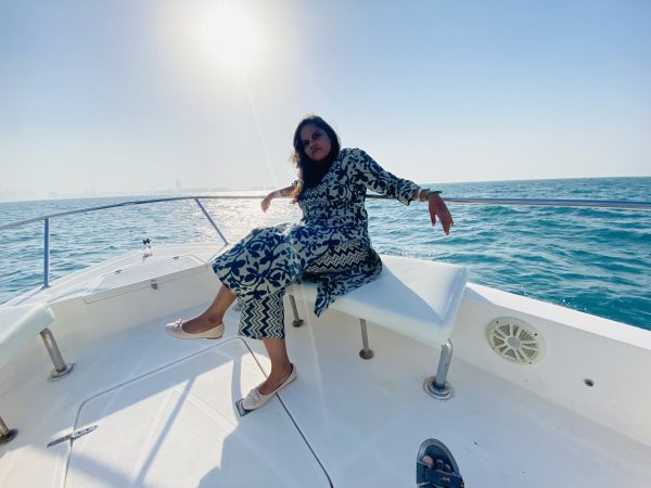 Dubai Boat Trip :A young woman smiling and enjoying the views from the bow of an MTS Yachts tour boat in Dubai Marina during a 90-minute sightseeing trip.
