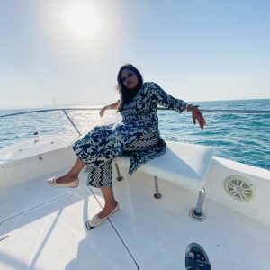 Dubai Boat Trip :A young woman smiling and enjoying the views from the bow of an MTS Yachts tour boat in Dubai Marina during a 90-minute sightseeing trip.